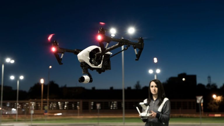 Woman flying drone at night - uas night operation