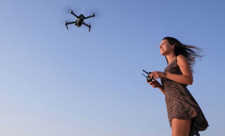 Woman flying drone - uk drone licences and regulations guide