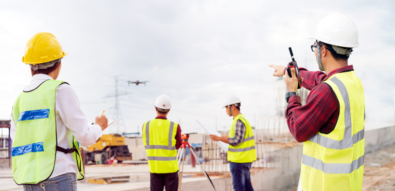 Drone flies over people at a construction site during a drone inspection