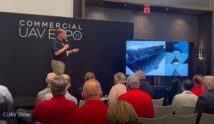 Man presenting in front of a panel of judges at the Commercial UAV Expo 2022