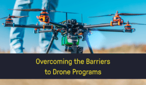 A drone with a text overlay which reads "Overcoming the Barriers to Drone Programs"