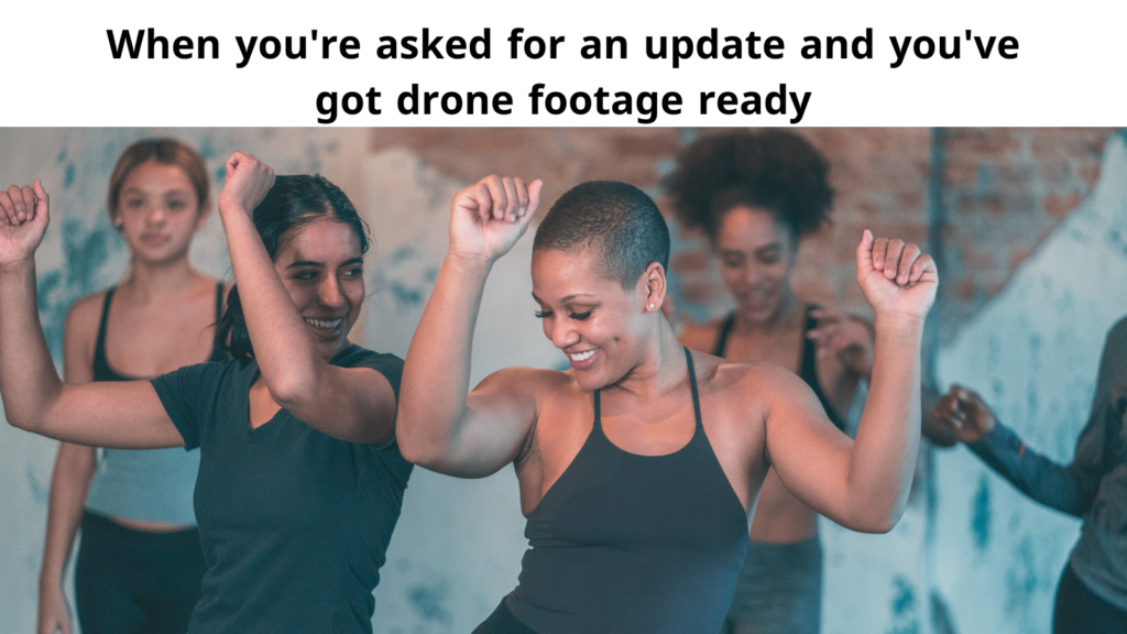 Group of women dancing energetically in a fitness class. The text above reads, 'When you're asked for an update and you've got drone footage ready,' humorously suggesting confidence and readiness.